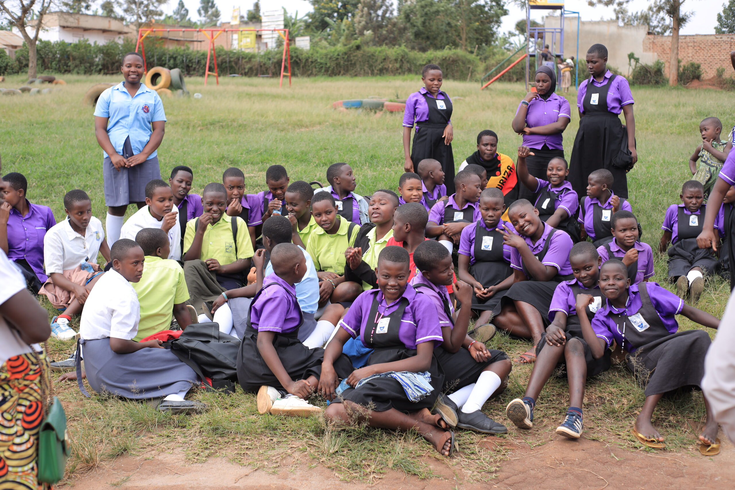 Refugee girls seated around the grass